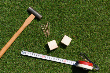 tools(hammer, nail, wood, measure) on turf