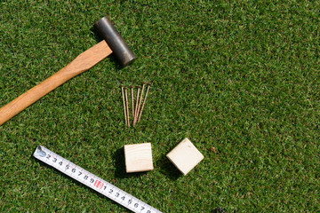 tools(hammer, nail, wood, measure) on turf