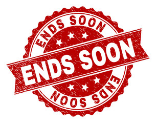 ENDS SOON seal print with distress texture. Rubber seal imitation has round medallion shape and contains ribbon. Red vector rubber print of ENDS SOON tag with retro texture.