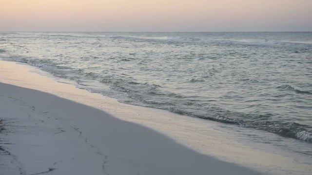 Dreamy pink pastel orange purple dark sunrise in Santa Rosa Beach, Florida with coastline coast in panhandle, closeup of ocean gulf of mexico waves, reflection, nobody in slow motion