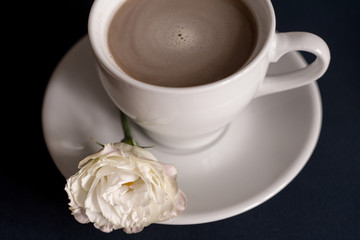 black coffee with milk in a white mug with a saucer