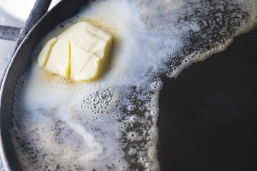 Butter in an old pan. On rustic background.