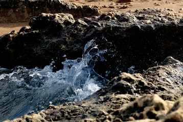 Powerful Waves on a rocky beach. Splits waves against rocks in the sea