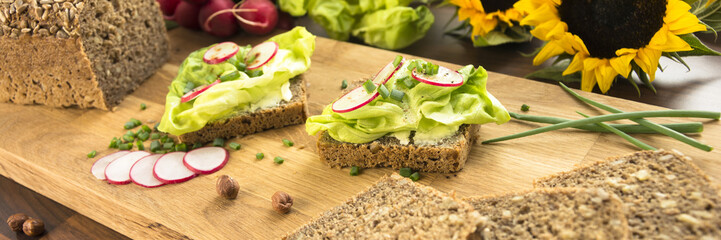 breakfast sandwich with vegetables on wooden cutting board