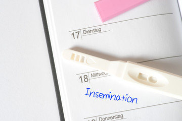 Ein Terminkalender, Schwangerschaftstest und ein Termin für künstliche Befruchtung Insemination