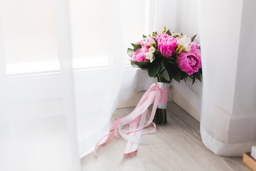 Beautiful pink peonies bouquet  with white and pink satin ribbons