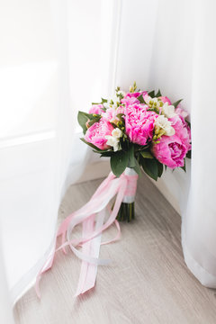 Beautiful pink peonies bouquet  with white and pink satin ribbons