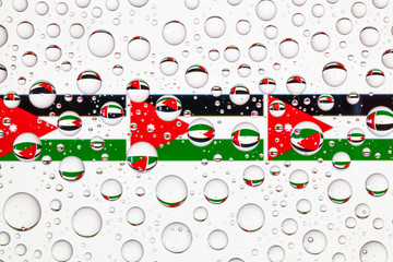 Water drops on glass and flags of Jordan