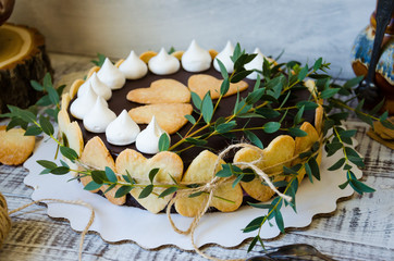 Cheesecake with gingerbread cookies on wood with greenery decoration