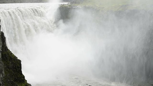Iceland Dettifoss waterfall, largest volume in Europe closeup, gray grey water, rocky cliff and water flowing mist spraying