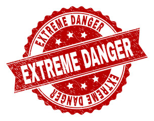 EXTREME DANGER seal print with distress texture. Rubber seal imitation has circle medallion form and contains ribbon. Red vector rubber print of EXTREME DANGER text with unclean texture.