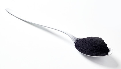 Stylish spoon heaped with edible charcoal
