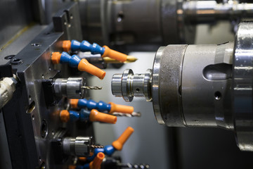 Operator machining automotive part by cnc turning machine,