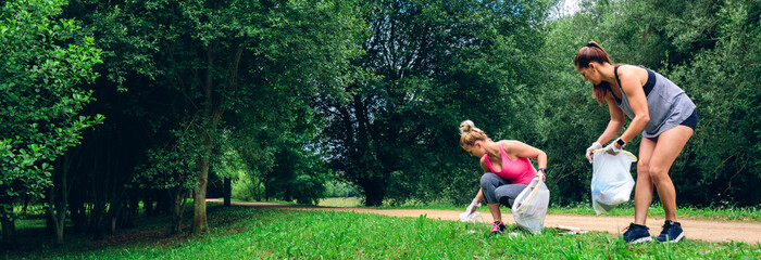 Two girls running with bags doing plogging outdoors