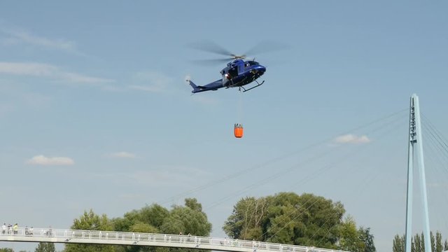 Fire brigade rescue helicopter carries water in the tank.