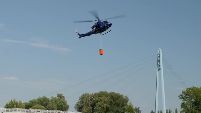 Fire fighting Helicopter, with bambi basket, during a fire fighting in nature.