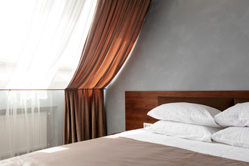 Bed maid-up with clean white pillows and bed sheets in beauty room.