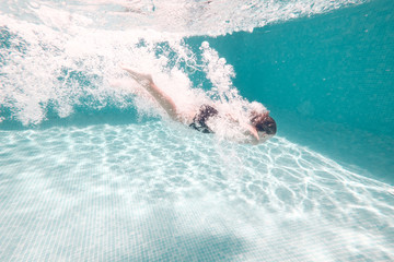 Boy dives into swimming pool