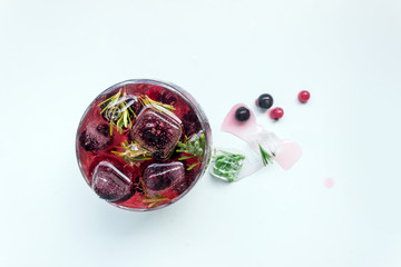 Cocktail of berries frozen in ice cubes (raspberries, blackberries , red and black currants) . Summer cold refreshing drink. Selective focus.Copy space.