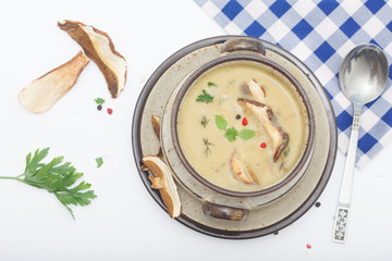 Delicious creamy mushroom soup with herbs. White background, top view.