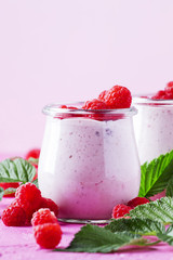 Raspberry smoothie with berry and yogurt on pink background, selective focus