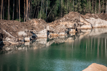 Beautiful sandstone quarry with emerald water, wild landscape and industry