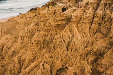 Yellow sand hills and rocks on the wild coast