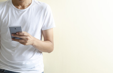 The man on white t-shirt using smartphone