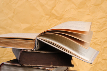 The open book lies on a pile of books. Front view.