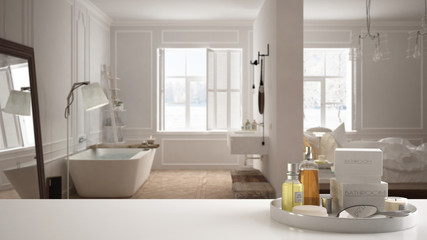 Fototapeta na wymiar Spa, hotel bathroom concept. White table top or shelf with bathing accessories, toiletries, over blurred white scandinavian bathroom, modern architecture interior design