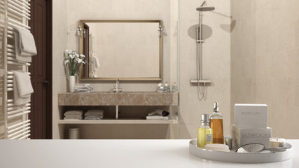 Spa, hotel bathroom concept. White table top or shelf with bathing accessories, toiletries, over blurred classic bathroom, modern architecture interior design