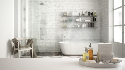 Spa, hotel bathroom concept. White table top or shelf with bathing accessories, toiletries, over blurred vintage classic bathroom, modern architecture interior design