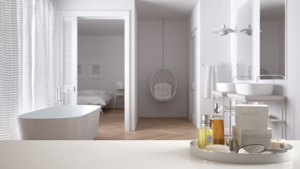 Spa, hotel bathroom concept. White table top or shelf with bathing accessories, toiletries, over blurred classic bathroom, modern architecture interior design