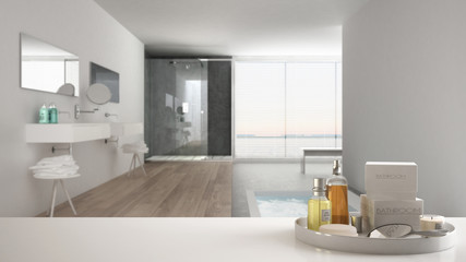 Spa, hotel bathroom concept. White table top or shelf with bathing accessories, toiletries, over blurred minimalist bathroom, modern architecture interior design