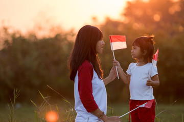 mom and kid together with indonesian flag