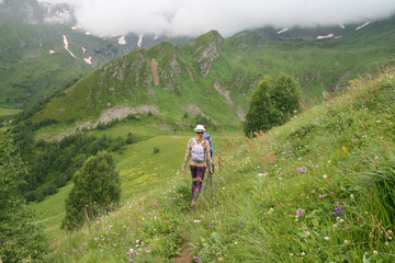 Tourists go on an alpine meadow. Arkhyz.