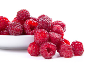 Harvested juicy ripe raspberries fruit on white background..
