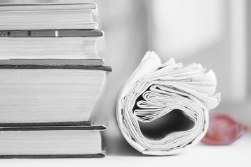 Pile of books and rolled newspapers, business concept   