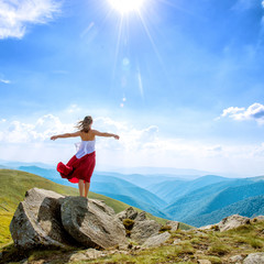 Young woman on the top of mountain