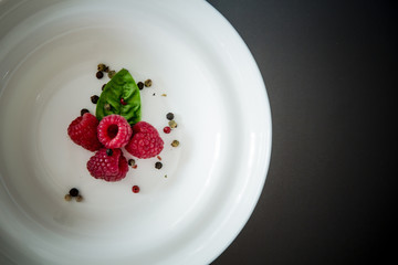  Red raspberry / Fresh ripe fruit served on a white plate. Flat lay minimalistic concept with copy space