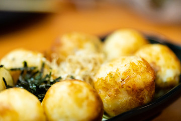 traditional japanese local food takoyaki.delicious seafood takoyaki with seaweed on black plate.japanese chef cook takoyaki for customer at japanese restaurant and cafe.takoyaki.