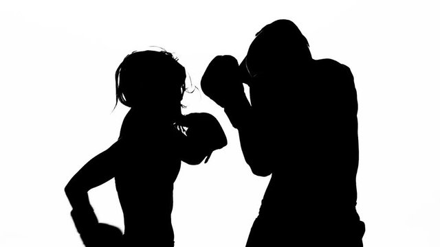 Men with a girl boxing gloves beating in the ring . Silhouette. White background. Slow motion