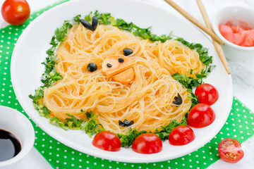 Japanese style kids breakfast or lunch shaped cute yellow chick or duck from rice noodles funchoza with green onion and cherry tomatoes