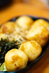 traditional japanese local food takoyaki.delicious seafood takoyaki with seaweed on black plate.japanese chef cook takoyaki for customer at japanese restaurant and cafe.takoyaki.