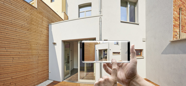 Holding a mobile Smartphone and take a picture of courtyard