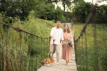 lovely couple walking with dog on the bridge