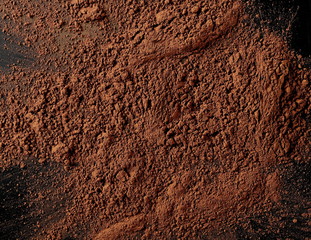 Cocoa powder pile isolated on black background, top view