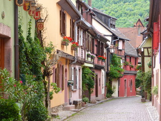 Kaysersberg en Alsace, ruelle avec des maisons colorées à colombages et encorbellement (France)