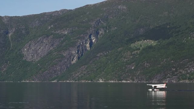Small white floatplane getting ready for takeoff in Eidfjord, Norway.