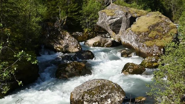 Glacier river passing some large boulders. Location river Jordalselvi in Hordaland, Norway.